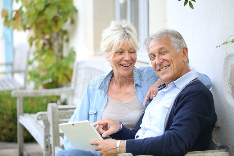 Hoger paar die pret met tablet hebben stock fotografie Hoger paar die pret met tablet hebben stock fotografie