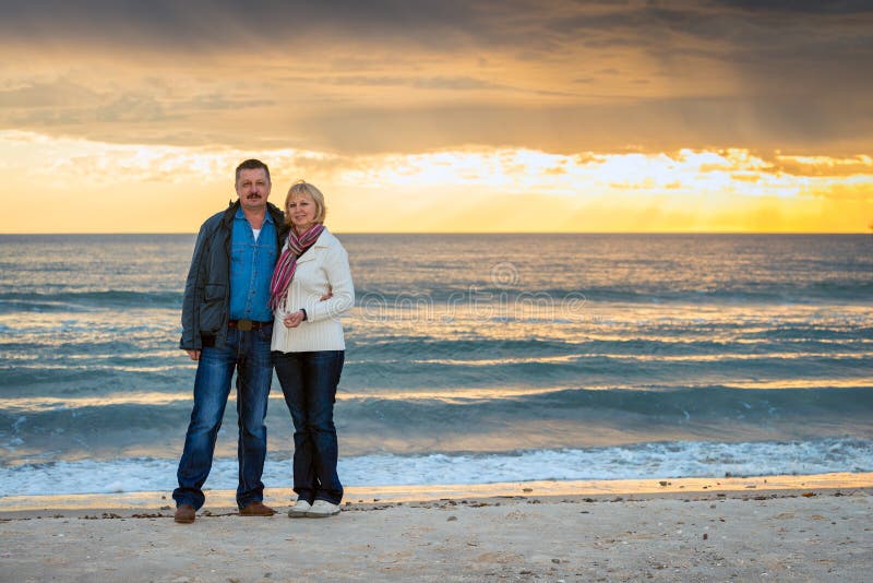 Hoger paar die zich bij het strand bevinden stock afbeelding Hoger paar die zich bij het strand bevinden stock afbeelding