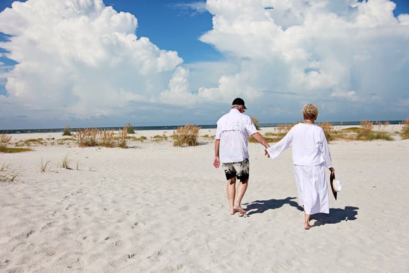 Hoger paar het lopen strand royalty-vrije stock afbeeldingen Hoger paar het lopen strand royalty-vrije stock afbeeldingen