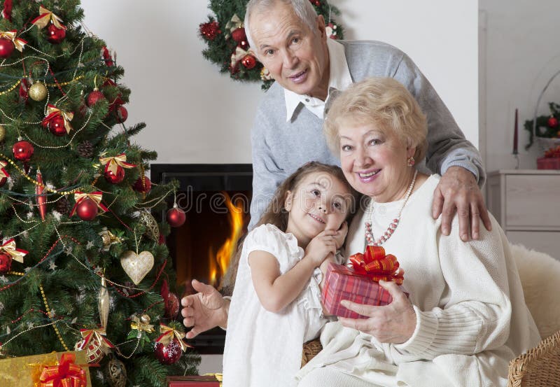 Hoger paar met kleindochter het vieren Kerstmis royalty-vrije stock foto Hoger paar met kleindochter het vieren Kerstmis royalty-vrije stock foto