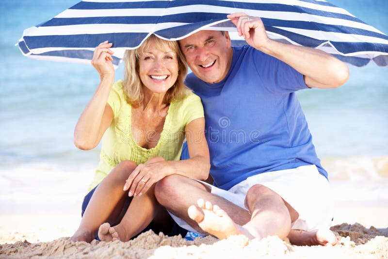 Hoger Paar onder de Paraplu van het Strand royalty-vrije stock foto Hoger Paar onder de Paraplu van het Strand royalty-vrije stock foto