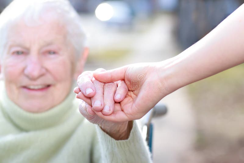 Hogere Dame en de Jonge Handen van de Holding van de Vrouw stock afbeelding Hogere Dame en de Jonge Handen van de Holding van de Vrouw stock afbeelding