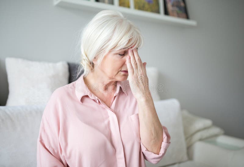 Hogere dame met migraine wat betreft haar voorhoofd royalty-vrije stock afbeeldingen Hogere dame met migraine wat betreft haar voorhoofd royalty-vrije stock afbeeldingen