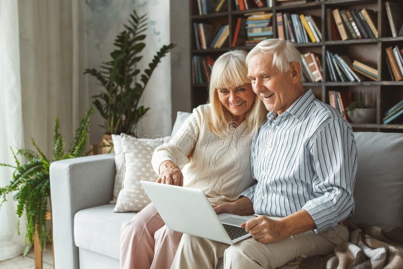 Hogere het conceptenzitting die van de paar samen thuis pensionering laptop met behulp van die op het scherm richten royalty-vrije stock foto Hogere het conceptenzitting die van de paar samen thuis pensionering laptop met behulp van die op het scherm richten royalty-vrije stock foto