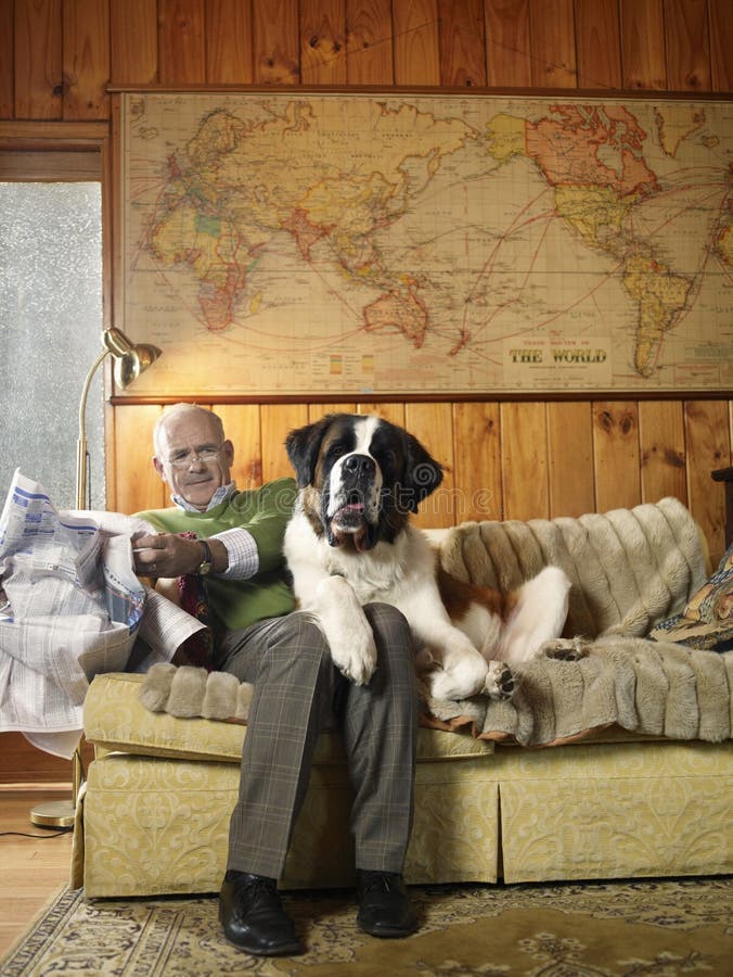 Hogere Mens die Sofa With Large St Bernard-Hond delen royalty-vrije stock afbeeldingen Hogere Mens die Sofa With Large St Bernard-Hond delen royalty-vrije stock afbeeldingen