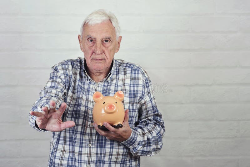 Hogere mens met een piggybank stock fotografie Hogere mens met een piggybank stock fotografie