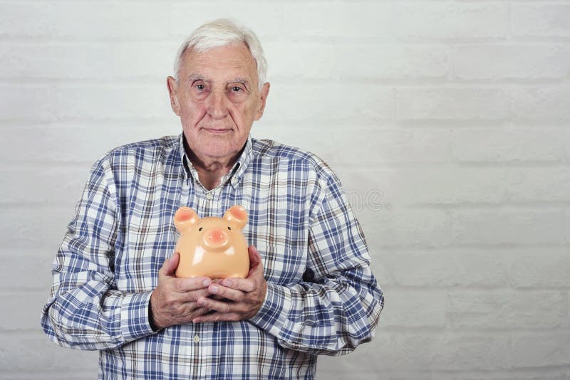 Hogere mens met een piggybank stock fotografie Hogere mens met een piggybank stock fotografie