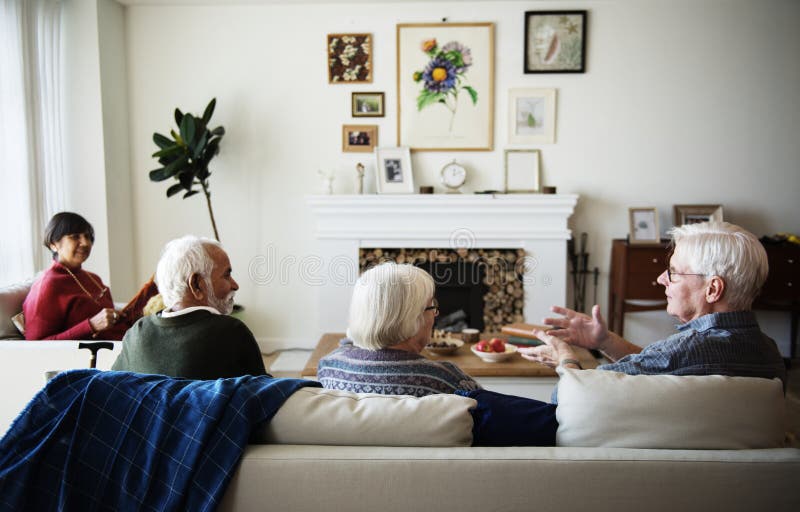 Hogere mensen die in een woonkamer spreken royalty-vrije stock afbeeldingen Hogere mensen die in een woonkamer spreken royalty-vrije stock afbeeldingen