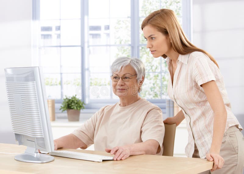 Hogere moeder en dochter die computer met behulp van stock fotografie Hogere moeder en dochter die computer met behulp van stock fotografie