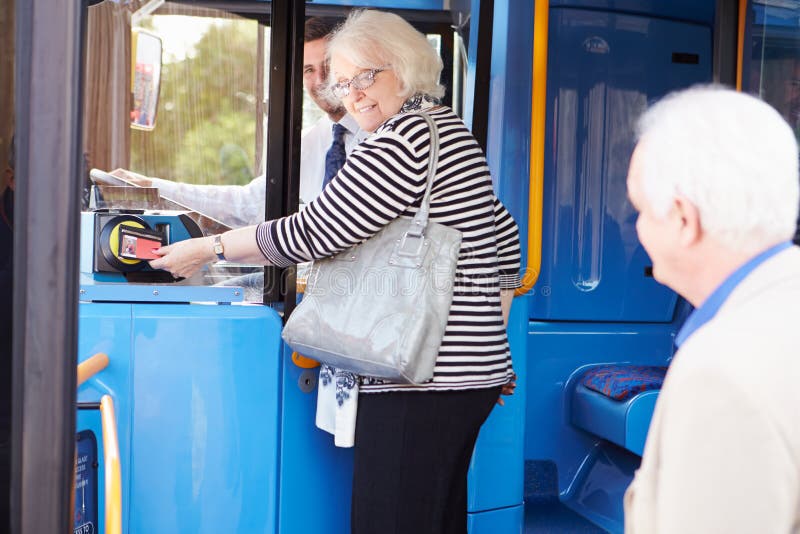 Hogere Paar het Inschepen Bus en het Gebruiken van Pas royalty-vrije stock afbeelding Hogere Paar het Inschepen Bus en het Gebruiken van Pas royalty-vrije stock afbeelding