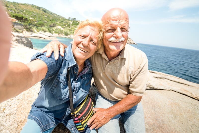 Hogere paarvakantieganger die selfie terwijl het hebben van echte pret bij Giglio-Eiland - Excursiereis in kustscenario nemen stock foto Hogere paarvakantieganger die selfie terwijl het hebben van echte pret bij Giglio-Eiland - Excursiereis in kustscenario nemen stock foto