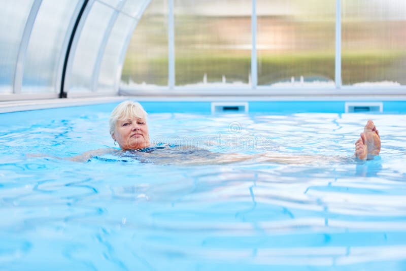 Senior woman doing rehab backstroke in the hydrotherapy pool. Senior woman doing rehab backstroke in the hydrotherapy pool