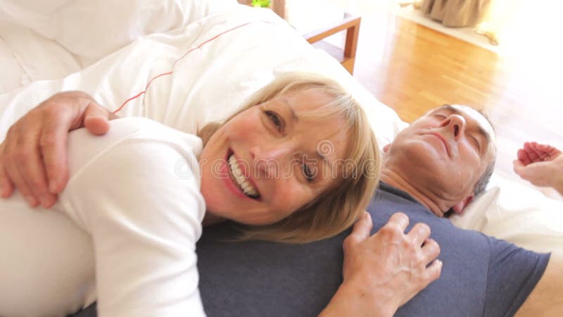 Hogere vrouw die op echtgenoten liggen