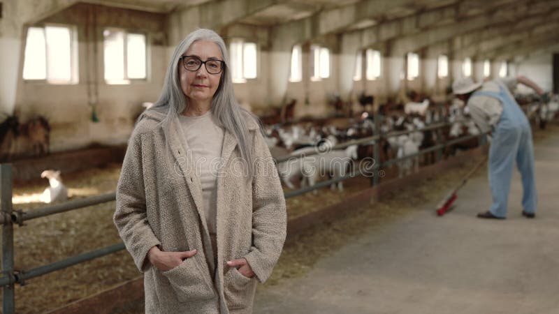 Hogere vrouw en jonge man die werkzaam is op de geitenhouderij