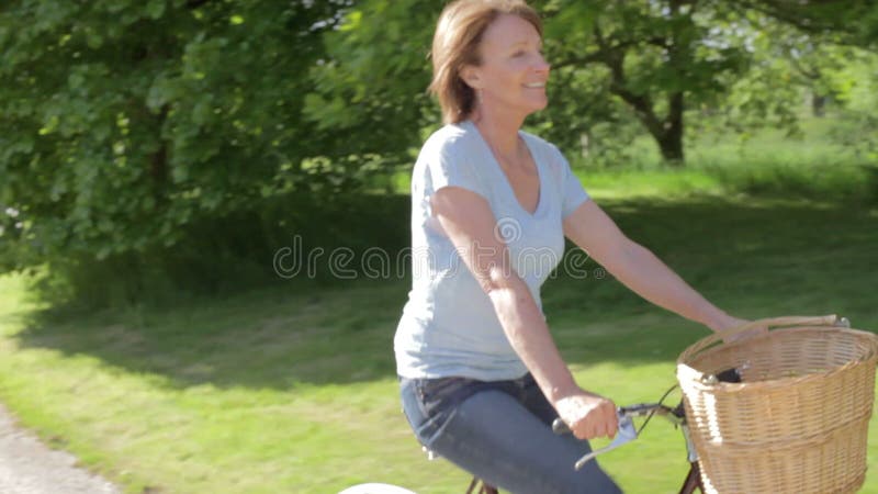 Hogere Vrouwen Berijdende Fiets langs het Spoor van het Land