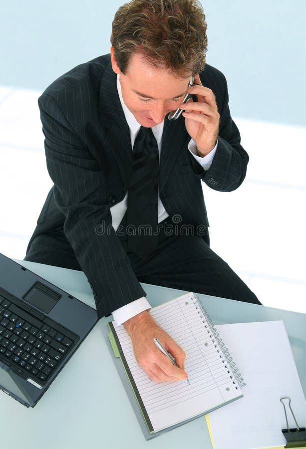 Senior businessman taking note and talking on the phone with client. Senior businessman taking note and talking on the phone with client