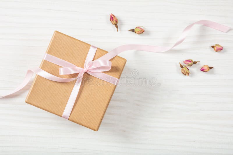 Hohe und Draufsicht des Abschlusses der beige Handwerksgeschenkbox mit rosa seidigem Band auf einem hölzernen Hintergrund, Kopien stockfoto Hohe und Draufsicht des Abschlusses der beige Handwerksgeschenkbox mit rosa seidigem Band auf einem hölzernen Hintergrund, Kopien stockfoto