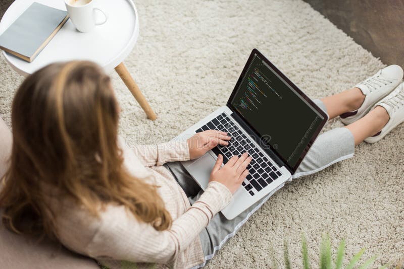 hohe Winkelsicht der jungen weiblichen Entwicklerkodierung mit Laptop stockbild hohe Winkelsicht der jungen weiblichen Entwicklerkodierung mit Laptop stockbild