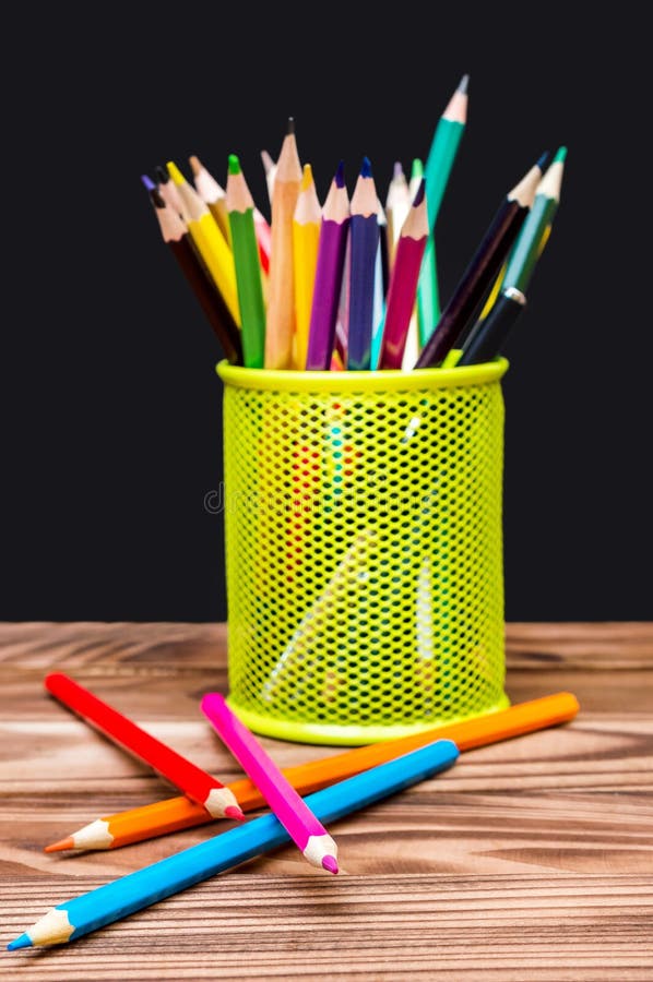 Holder with Color Pencils on the Table Against Blackboard Stock Image