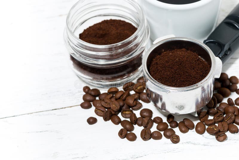 Holder with Ground Coffee and Cup of Coffee on White Table Stock Image