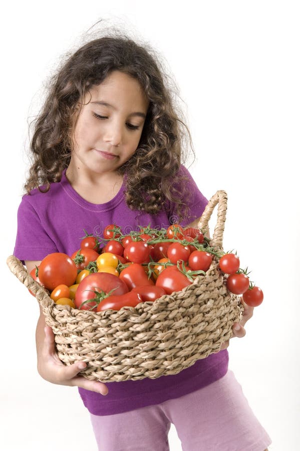 Holdin della ragazza un cestino dei pomodori fotografia stock libera da diritti Holdin della ragazza un cestino dei pomodori fotografia stock libera da diritti