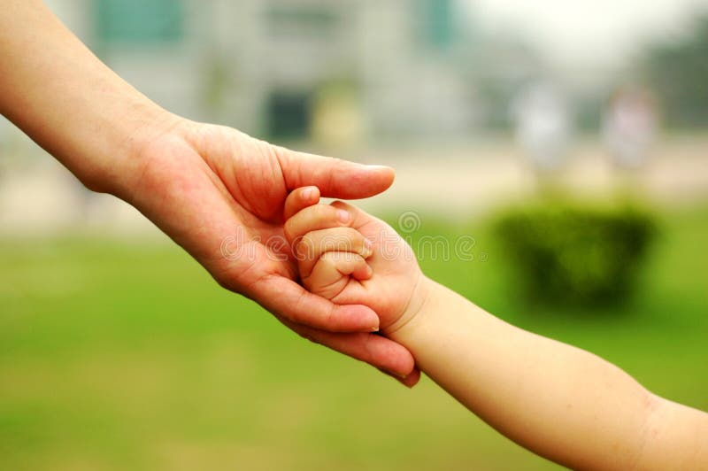 Mother is holding child's palm.