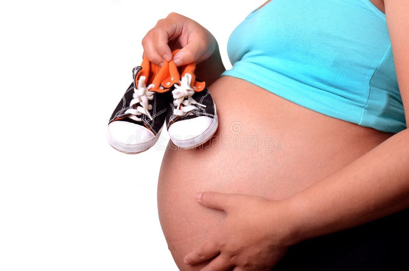 Holding-Babyschuh der schwangeren Frau
