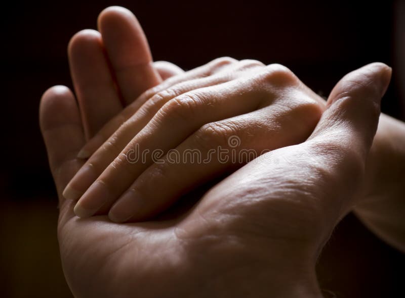 Muž a žena drží navzájem ruce.