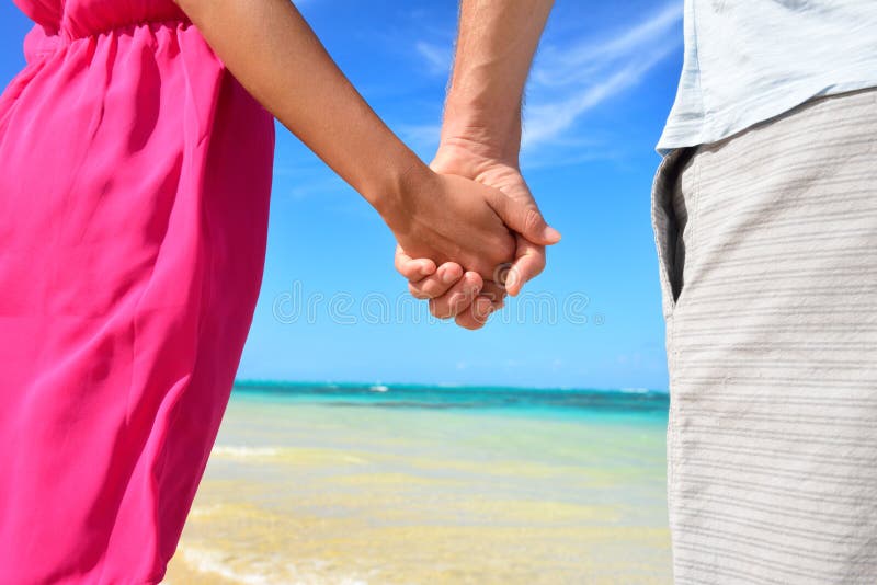 Holding hands romantic newlyweds couple on beach stock photo Holding hands romantic newlyweds couple on beach stock photo