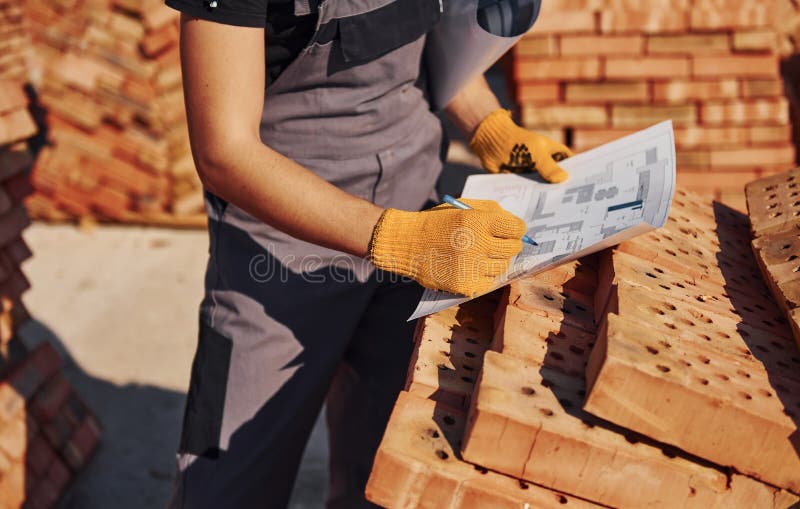 Holding Plan in Hands. Construction Worker in Uniform and Safety