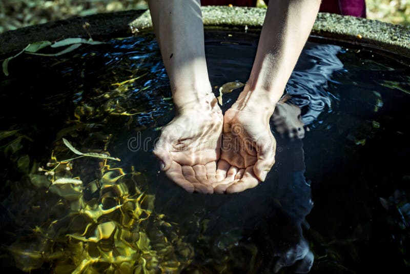 Holding water from a well in cupped hands stock photography Holding water from a well in cupped hands stock photography