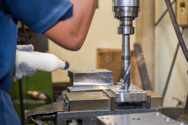 The hole drilling process on NC milling machine with liquid coolant method royalty free stock photo