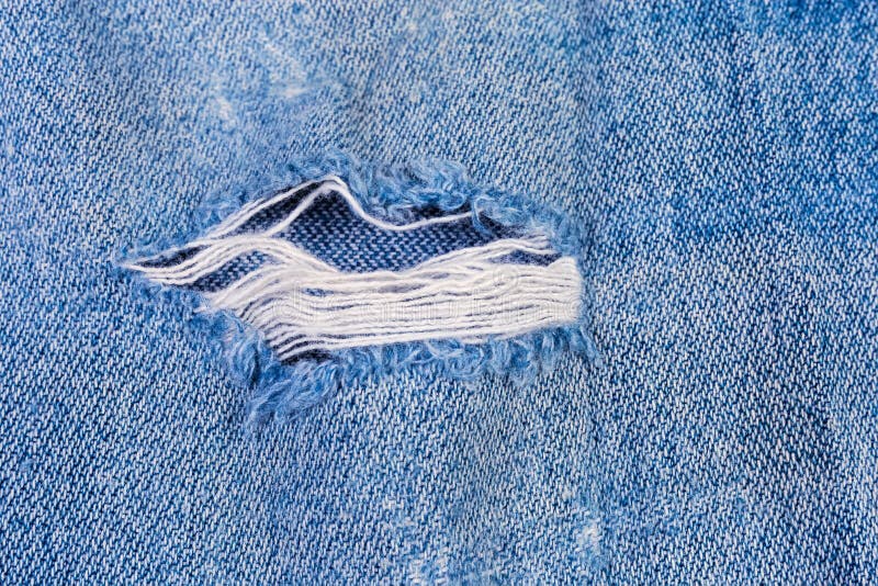 Hole With Frayed Threads In An Old Torn Blue Jeans Stock Photo - Image ...