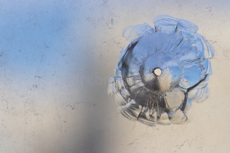The hole in the glass is pierced by a bullet of an air rifle stock photos The hole in the glass is pierced by a bullet of an air rifle stock photos
