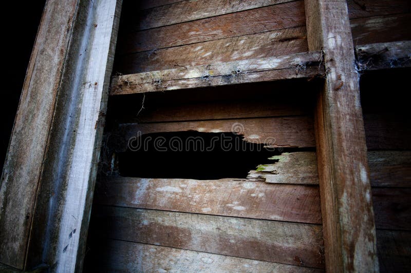 Hole in old wooden wall