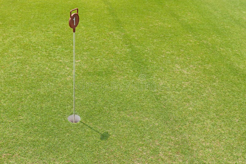 Hole at putting cup hold showing number one pin at outdoor practice putting green