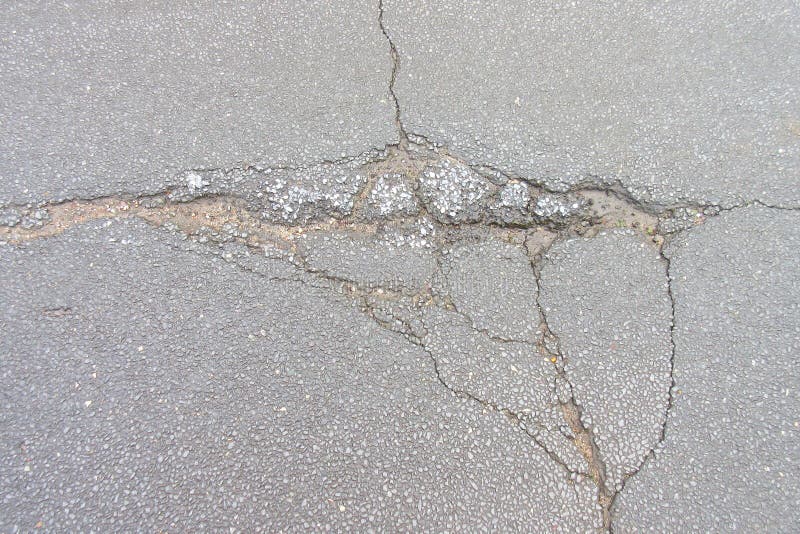 Holes and damage on an asphalt road. Close-up stock photo