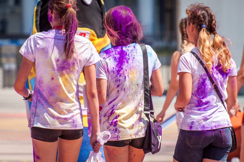 Holi di festa Tre ragazze sono spruzzate con le polveri viola luminose fotografia stock Holi di festa Tre ragazze sono spruzzate con le polveri viola luminose fotografia stock