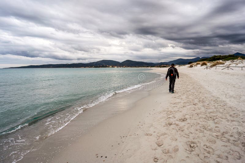On holiday alone in contact with nature to find yourself - A solo traveler with a backpacker walks at sunset or dawn along a stock images