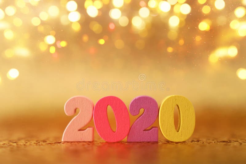 Holiday image of New Year 2020 concept. Wooden number and sparkling background