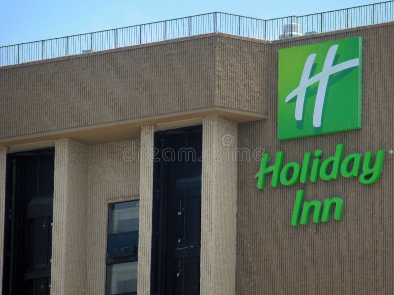 Holiday Inn is a chain of Intercontinental Hotels.  This signage is located in Burbank, California.  Green Lettering with logo on top of the hotel building. Holiday Inn is a chain of Intercontinental Hotels.  This signage is located in Burbank, California.  Green Lettering with logo on top of the hotel building.