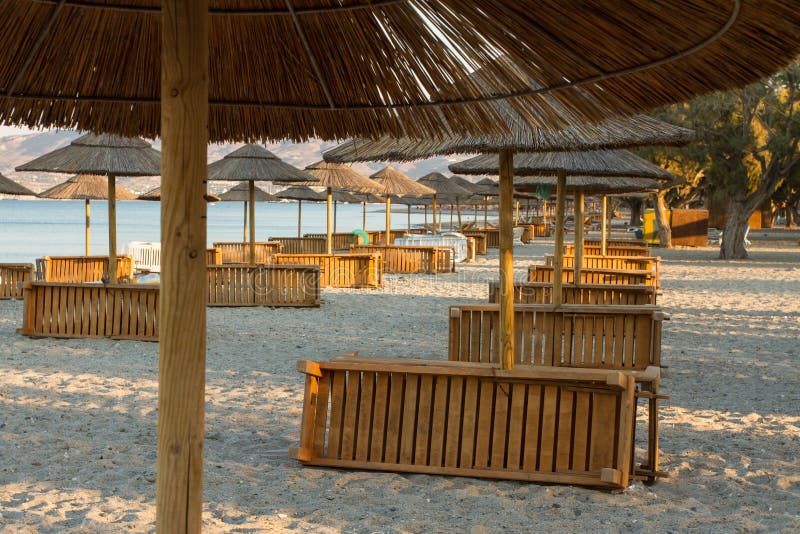 Holiday resort with a beach and sea view with sunshades at sunset. Holiday resort with a beach and sea view with wooden sunshades at sunset with nobody stock image Holiday resort with a beach and sea view with sunshades at sunset. Holiday resort with a beach and sea view with wooden sunshades at sunset with nobody stock image