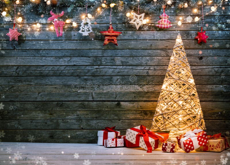 Holidays background with illuminated Christmas tree, gifts and d