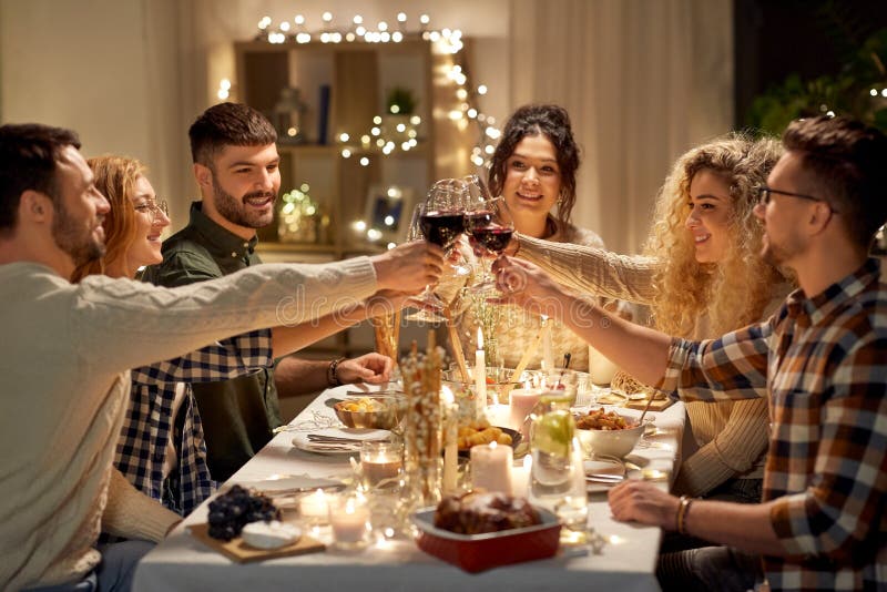 Happy friends drinking red wine at christmas party