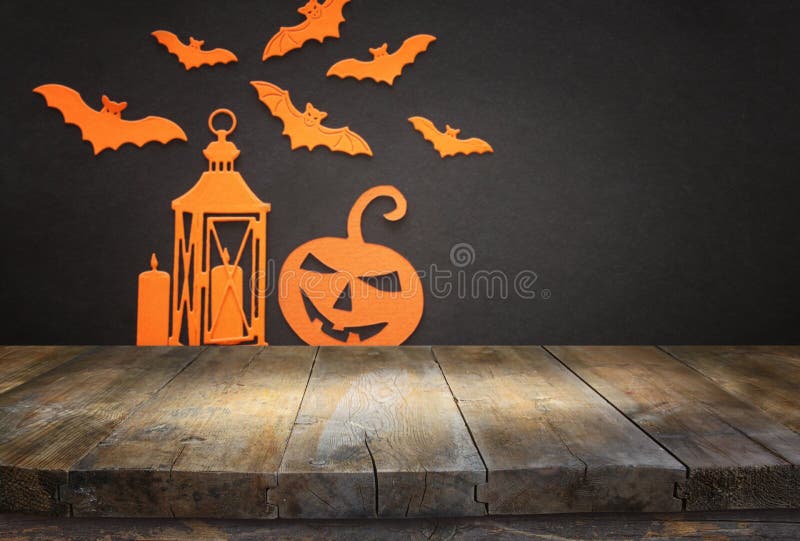 Holidays concept of Halloween. Empty rustic table in front of bats, pumpkin and lantern background. Ready for product display stock images Holidays concept of Halloween. Empty rustic table in front of bats, pumpkin and lantern background. Ready for product display stock images