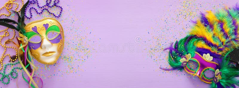 Holidays image of mardi gras masquarade, venetian mask and beads over purple background. view from above