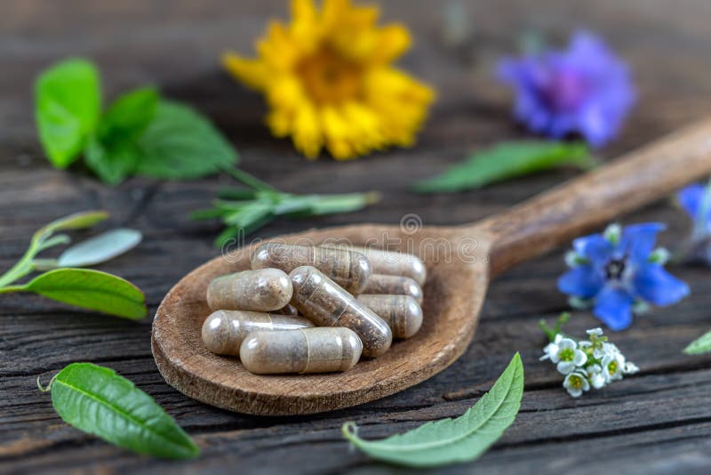 Holistic medicine approach. Healthy food eating, dietary supplements, healing herbs and flowers. wooden background, c.