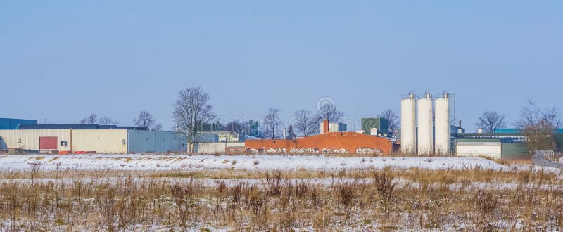 Holländskt branschlandskap med ett lager och några vita behållare, Majoppeveld en industriell terräng i staden av Roosendaal, royaltyfri foto Holländskt branschlandskap med ett lager och några vita behållare, Majoppeveld en industriell terräng i staden av Roosendaal, royaltyfri foto