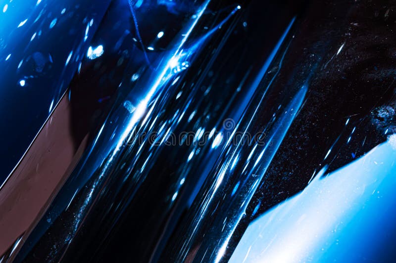 Holografische plastiek gerimpelde film met de lichte bezinningen van de contrastzon Blauwe tonen met donkere zwarte schaduwen royalty-vrije stock afbeeldingen Holografische plastiek gerimpelde film met de lichte bezinningen van de contrastzon Blauwe tonen met donkere zwarte schaduwen royalty-vrije stock afbeeldingen