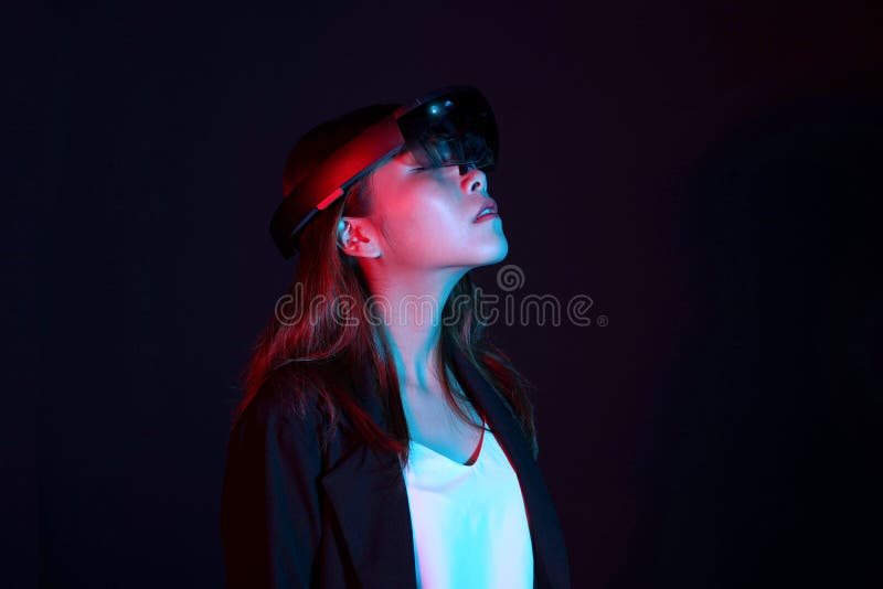 Hololens di vetro del vr di prova della donna di affari nella stanza scura | Ritratto di giovane esperienza asiatica AR della rag fotografia stock libera da diritti Hololens di vetro del vr di prova della donna di affari nella stanza scura | Ritratto di giovane esperienza asiatica AR della rag fotografia stock libera da diritti